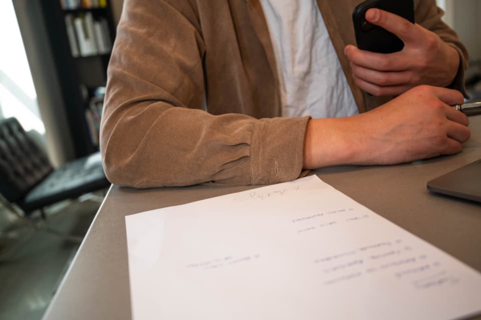 A person reading through a printed agreement at a desk